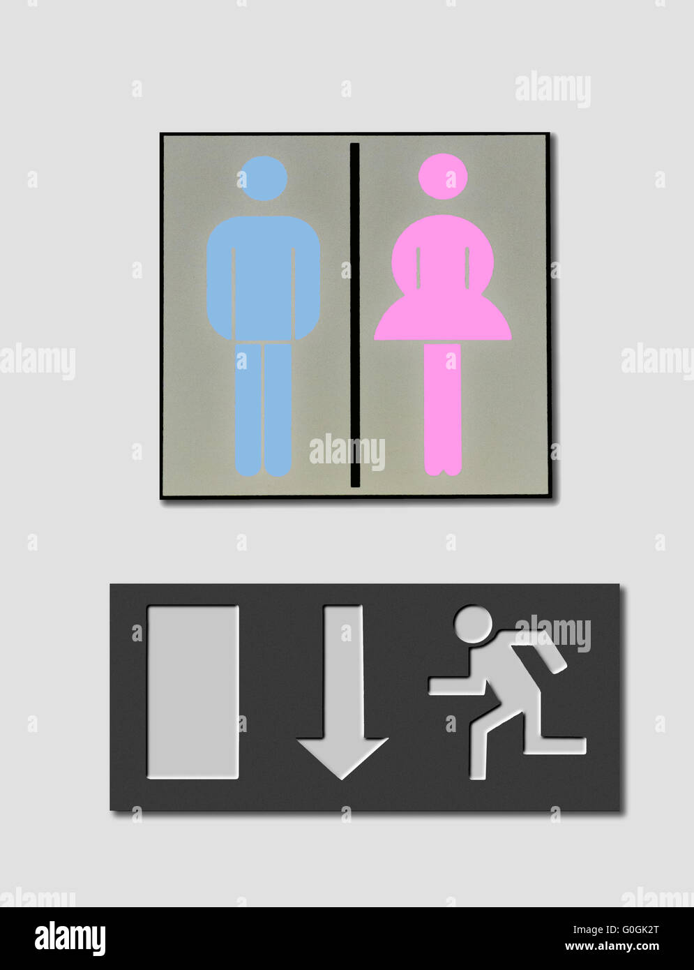 Toilette con signo femenino rosa y azul claro símbolo masculino y un indicador de ruta de escape Foto de stock