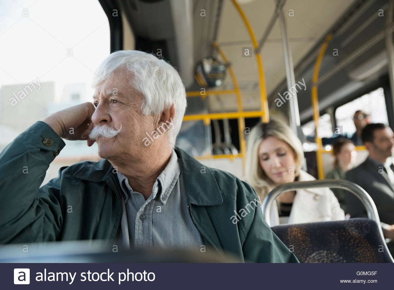 Pensativo hombre senior caballo mirando hacia afuera de la ventana del bus Foto de stock