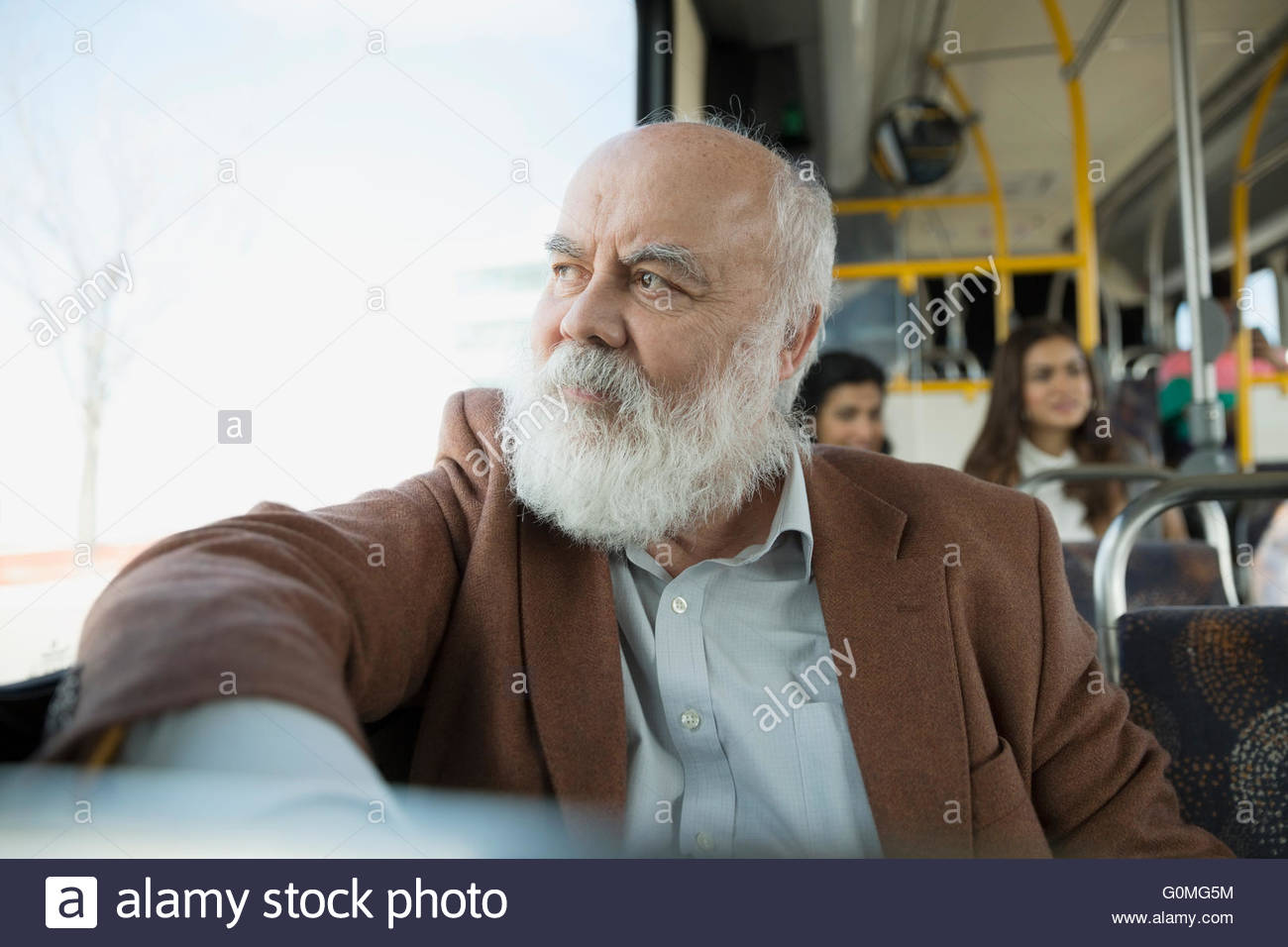 Pensativo hombre senior caballo mirando hacia afuera de la ventana del bus Foto de stock