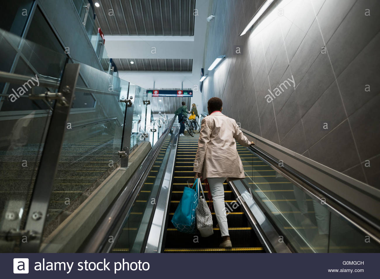 Mujer escalera ascendente en la estación de tren Foto de stock