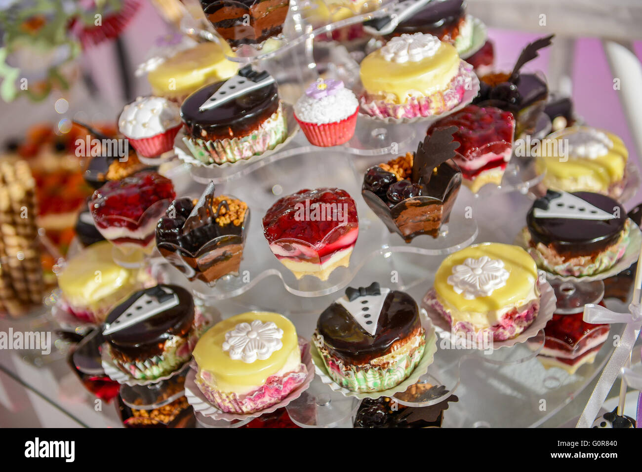 Muchos coloridos cupcakes sobre un soporte de plástico con luz lateral Foto de stock