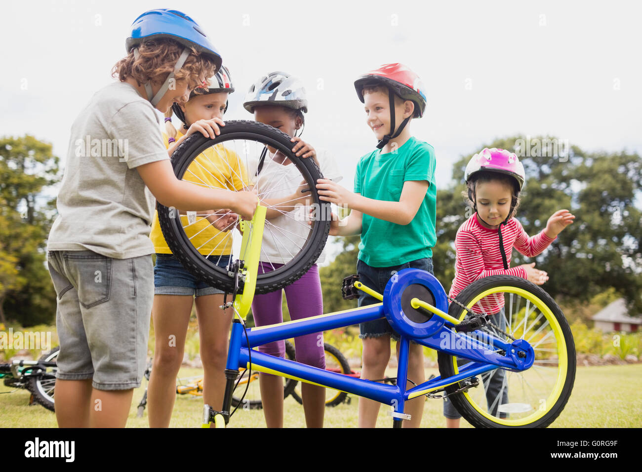Niños jugando con la bicicleta en el parque Fotografía de stock - Alamy