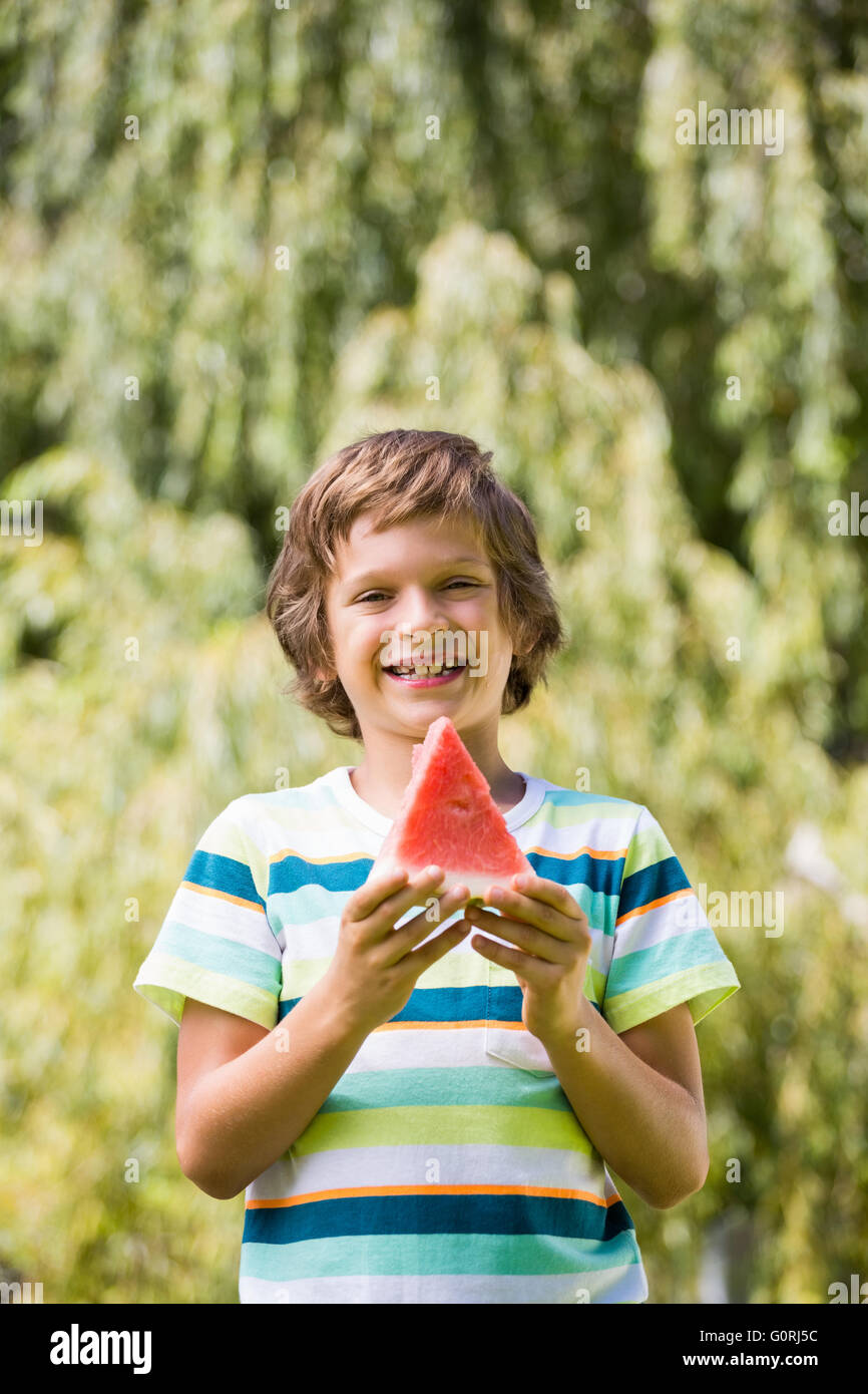 Un niño está sonriendo con una sandía Foto de stock