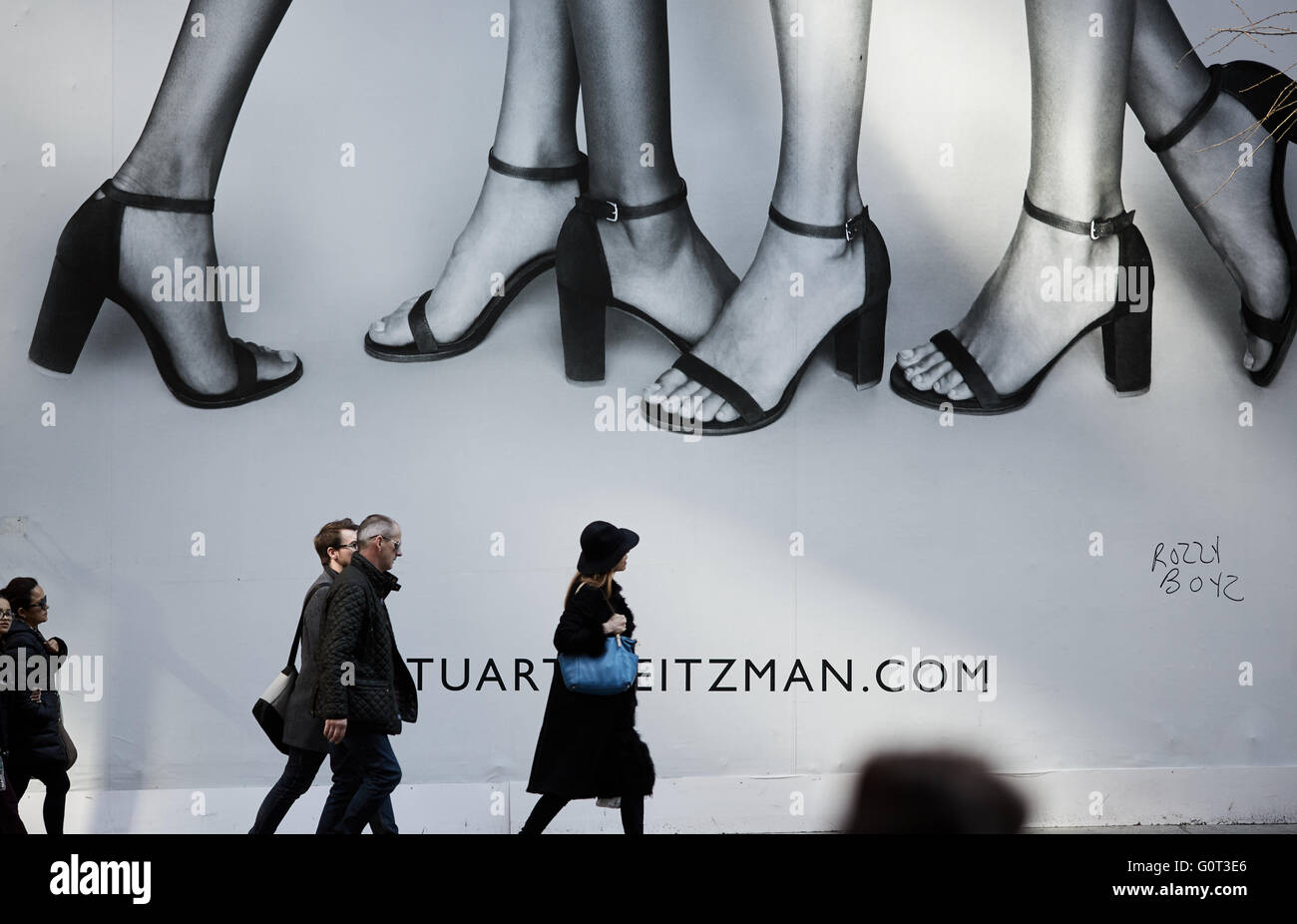 Nueva York anuncio de enormes dimensiones en la quinta avenida que cubre las tiendas la gente caminando en la acera pies zapatos de tacón Foto de stock