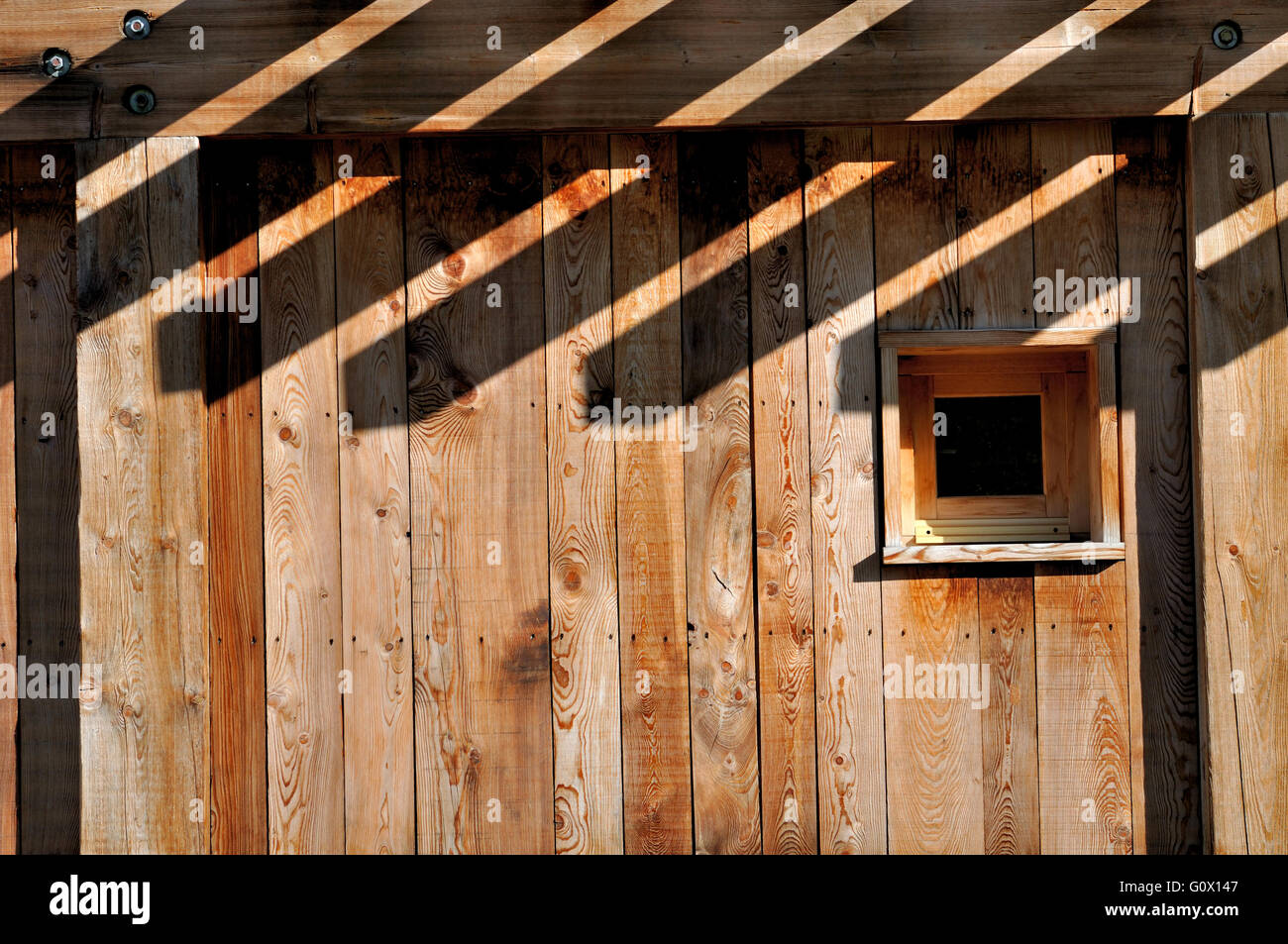 Sombras en una fachada de una cabaña de madera Foto de stock