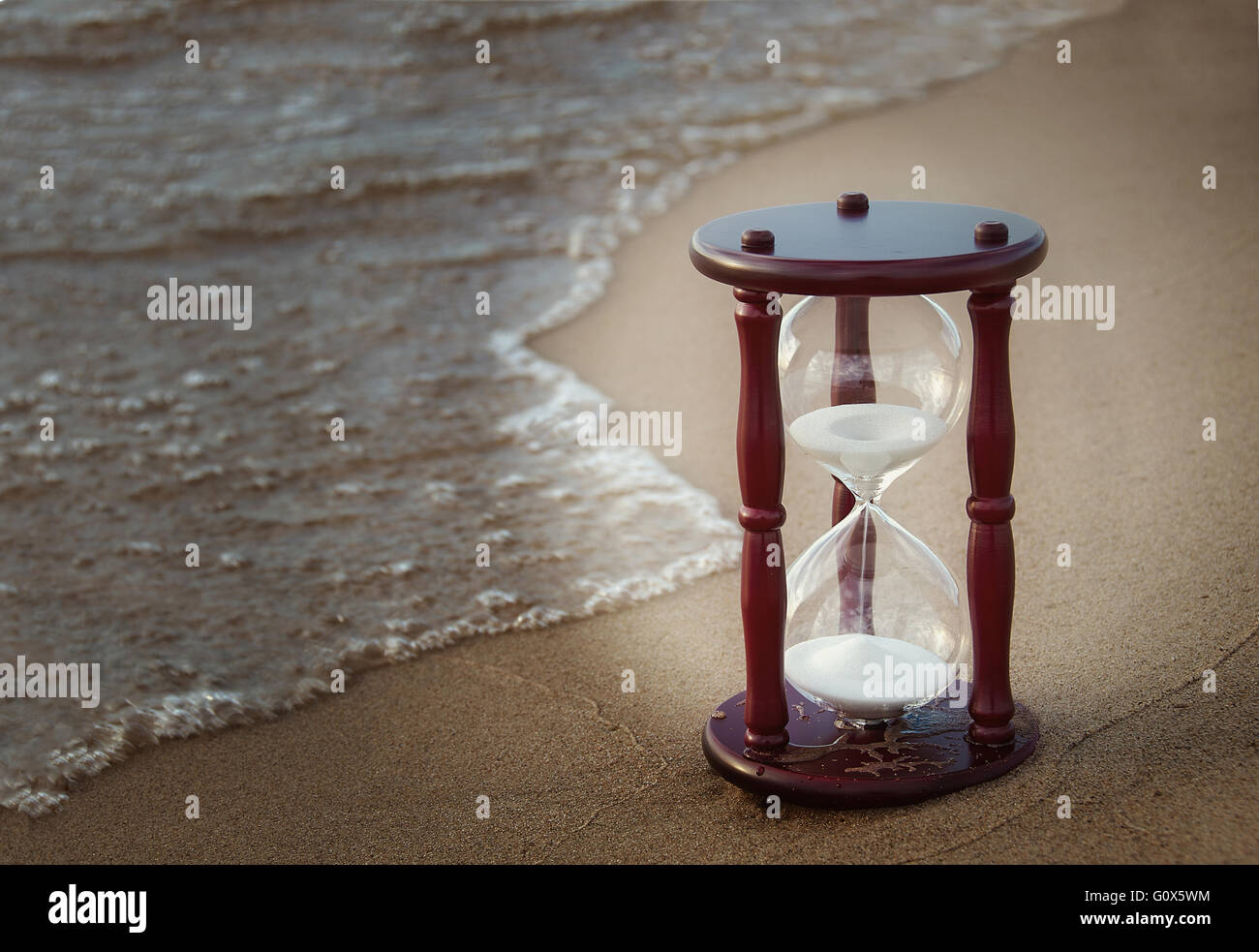 Reloj de arena en la playa con sombra vignette framing. Foto de stock