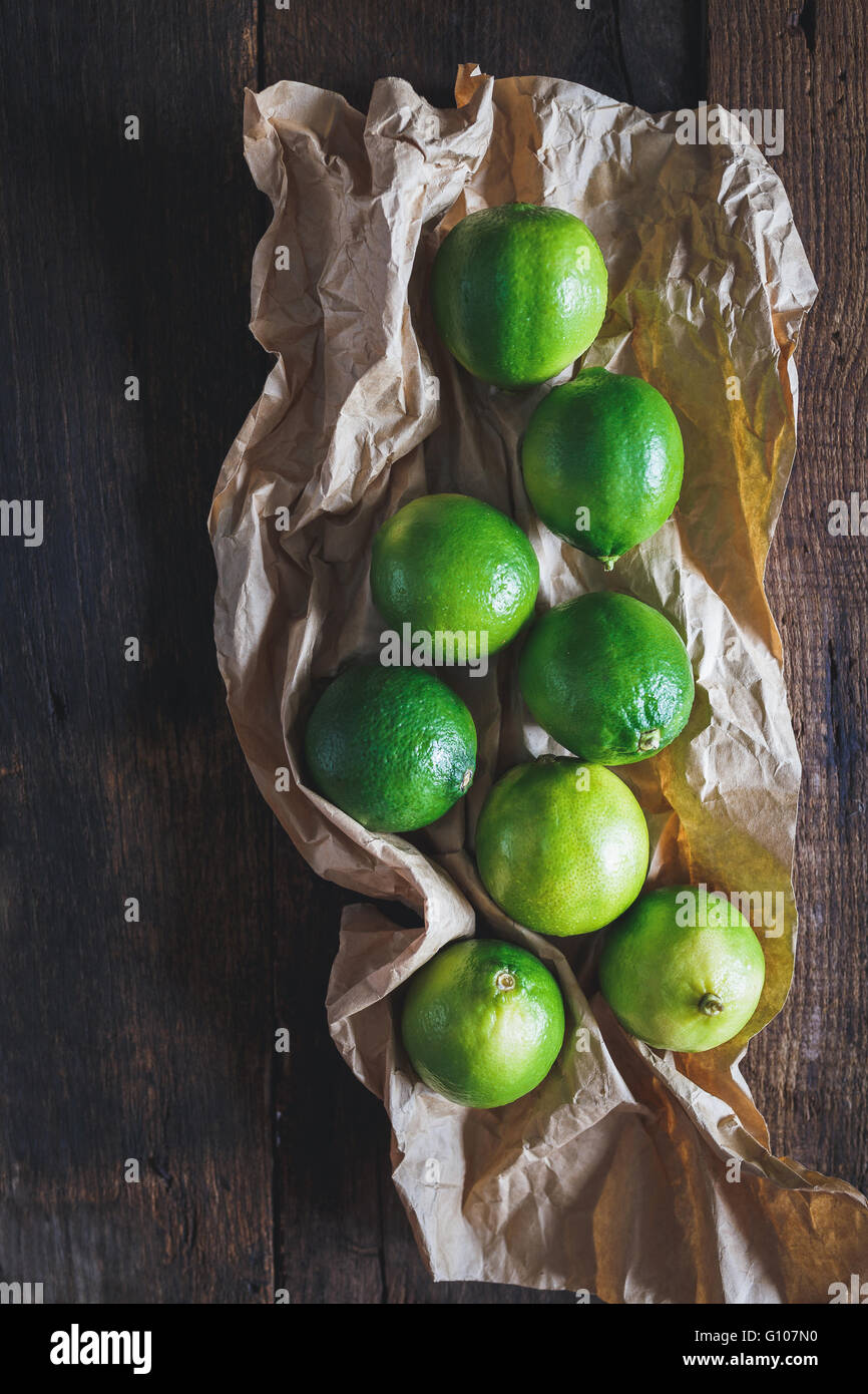 Limones verdes sobre la madera vieja Foto de stock