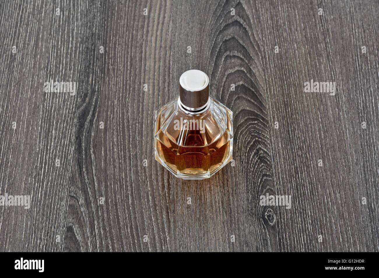 Una Botella de Perfume de mujer sobre una superficie de madera Foto de stock