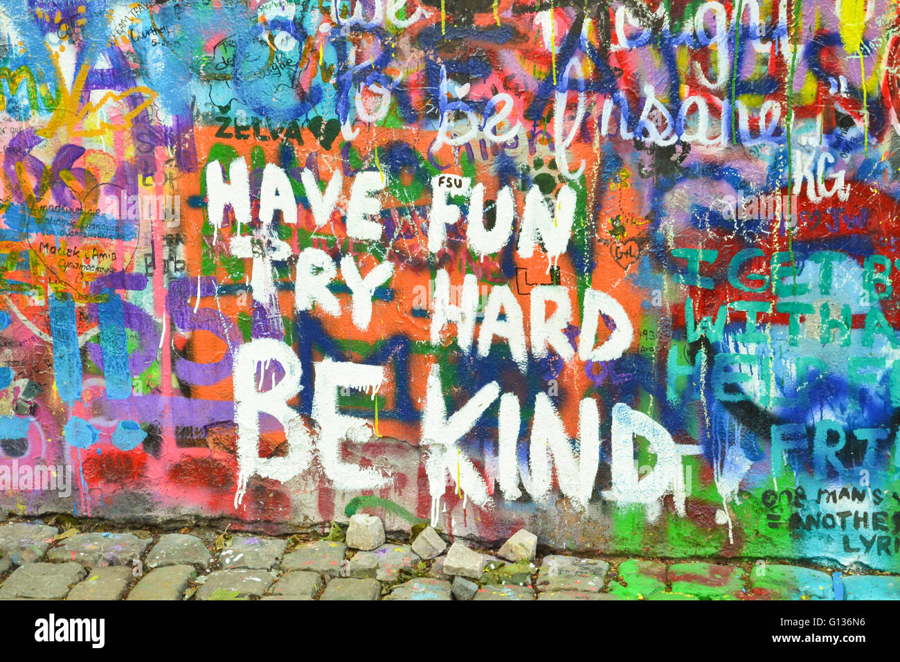 Divertirse, intente difícilmente, ser amable graffiti en muro John Lennon, Praga Foto de stock