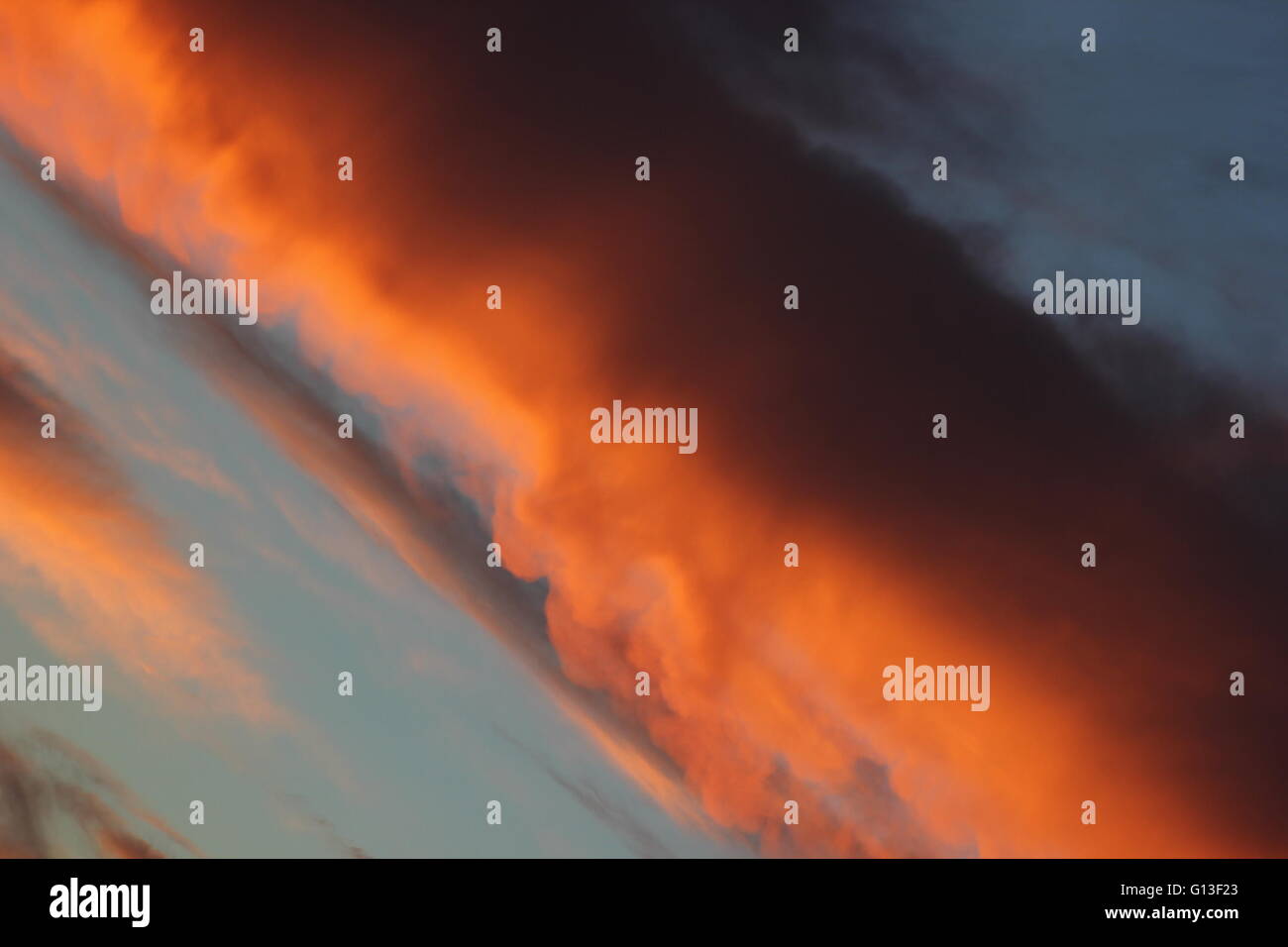 Quema en nube naranja atardecer en ángulo inusual. Foto de stock