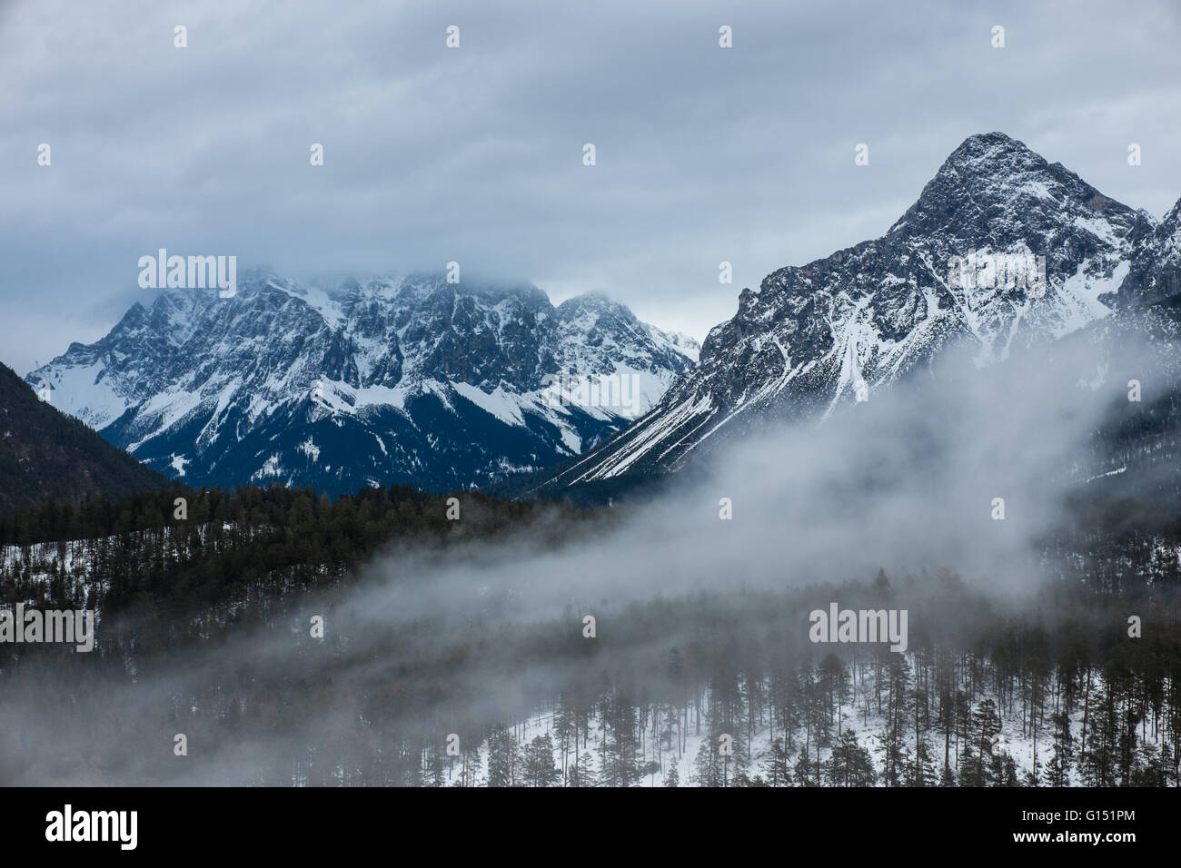 Zugspitze a la izquierda - la montaña más alta de Alemania en el frío clima invernal Foto de stock