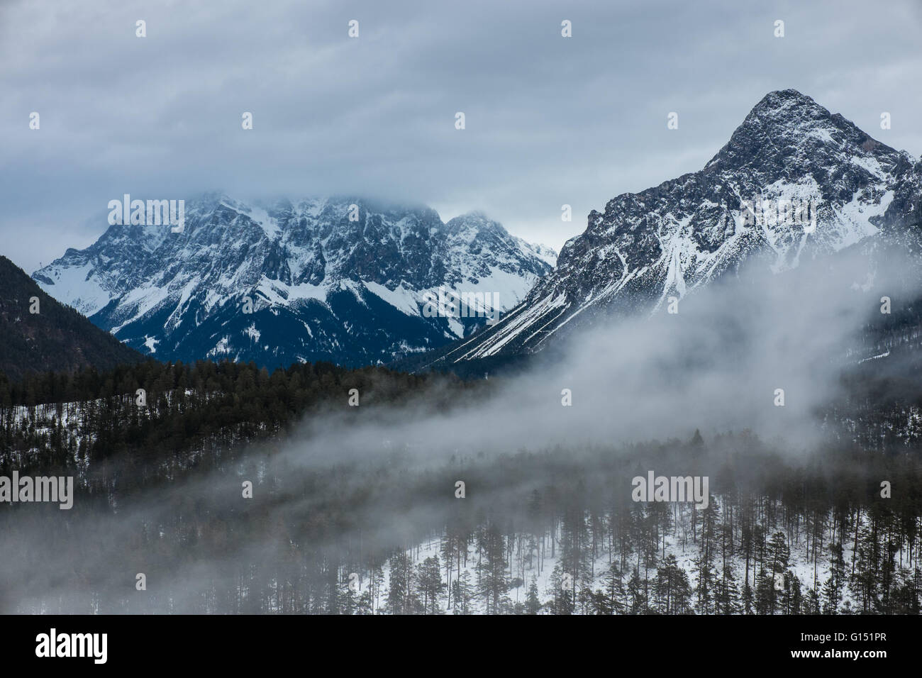Zugspitze a la izquierda - la montaña más alta de Alemania en el frío clima invernal Foto de stock