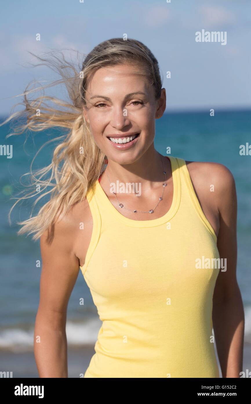 Retrato de mujer rubia sonriendo con amarillo tank top Foto de stock