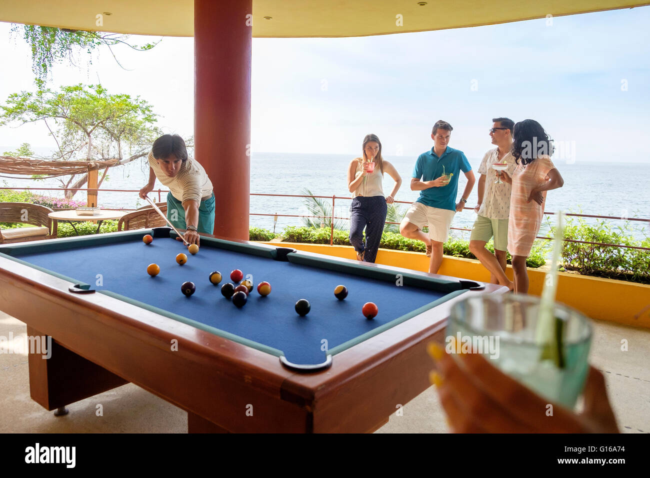 Personas con cóctel de bebidas mientras juega billar pool en la terraza de  una villa frente al mar en México Fotografía de stock - Alamy