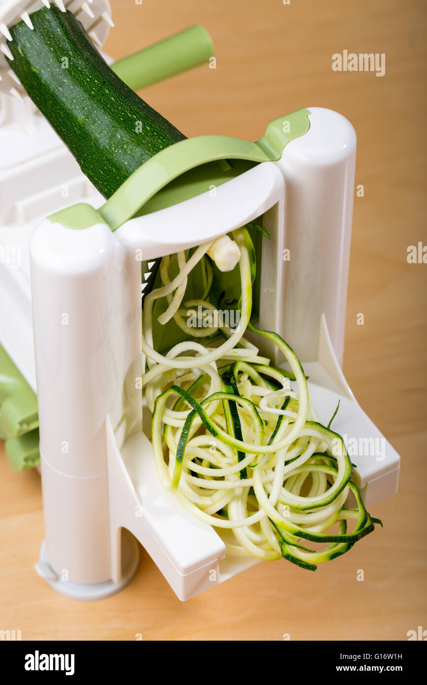 Haciendo el calabacín (zucchini) fideos (espaguetis) con un spiralizer Foto de stock