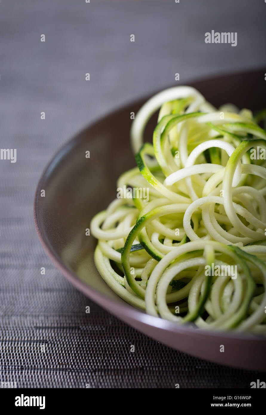 Un tazón de calabacín (zucchini) fideos (espaguetis) realizados mediante un spiralizer Foto de stock