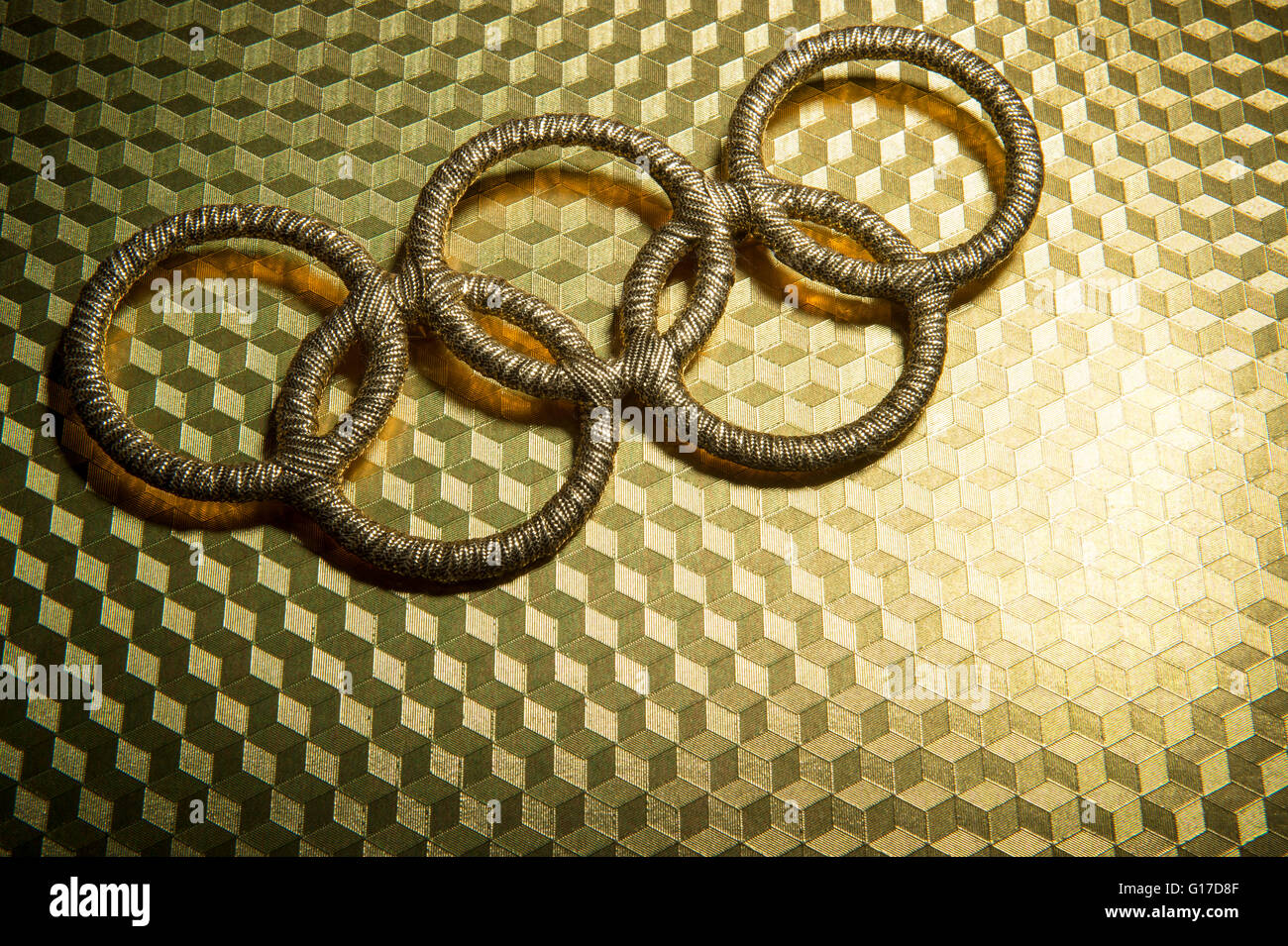 RIO DE JANEIRO - Febrero 3, 2015: el símbolo de los anillos olímpicos de oro se sienta spotlit sobre fondo dorado brillante. Foto de stock