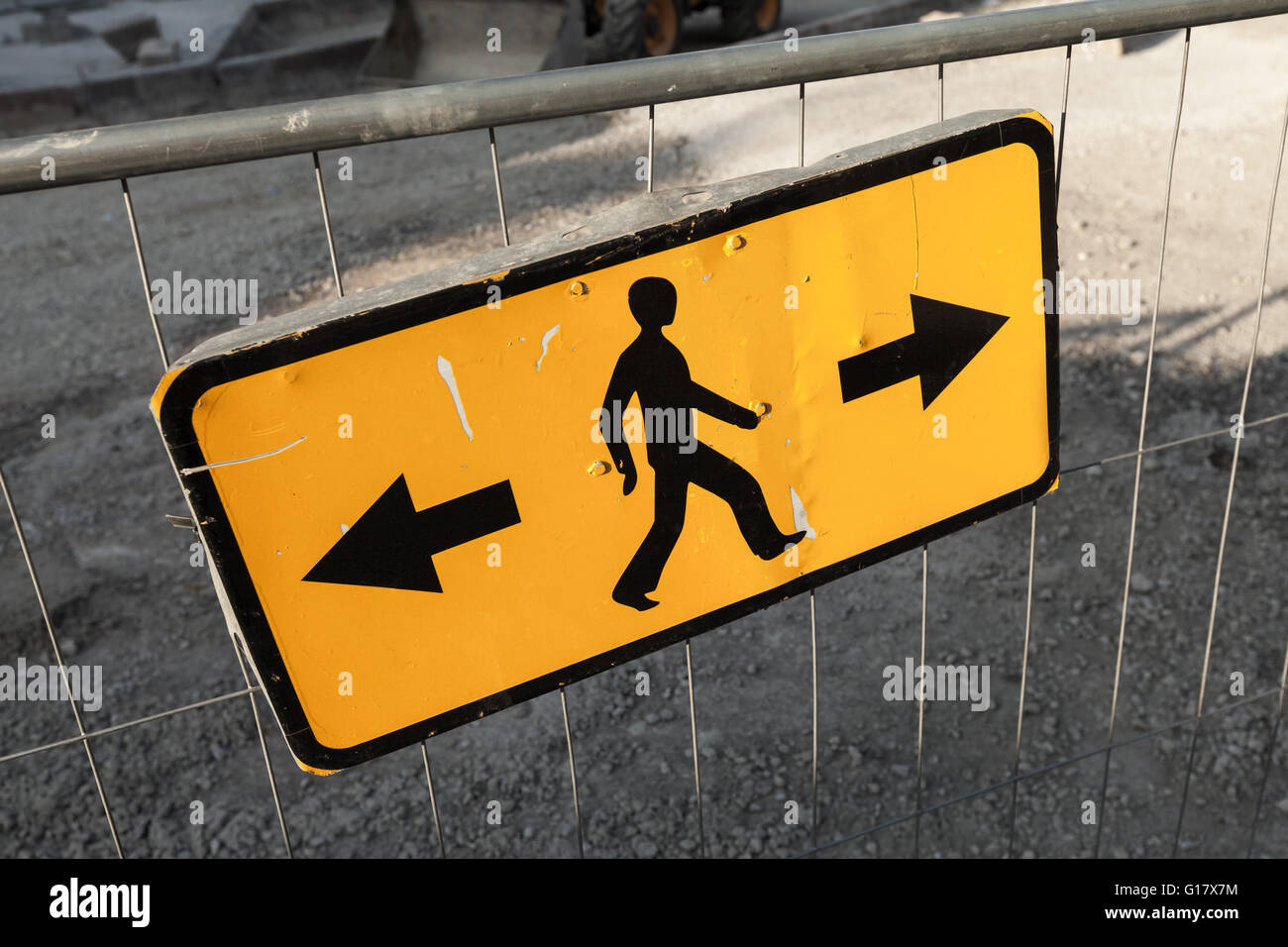Los peatones omitir direcciones. Señal de carretera amarilla en el borde del sitio de construcción Foto de stock