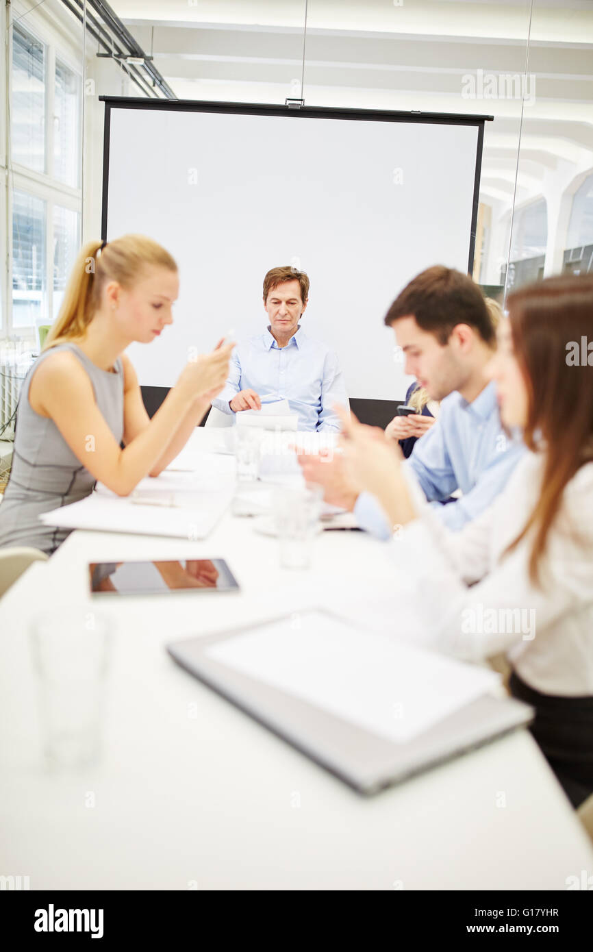 La comunicación empresarial a través de los smartphones en una reunión Foto de stock