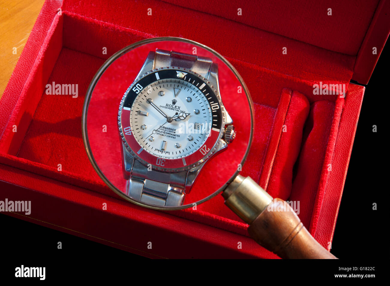 ROLEX FALSO RELOJ lupa aumento detalle en una réplica falso reloj Rolex  hombres en cuero rojo caja de reloj Fotografía de stock - Alamy