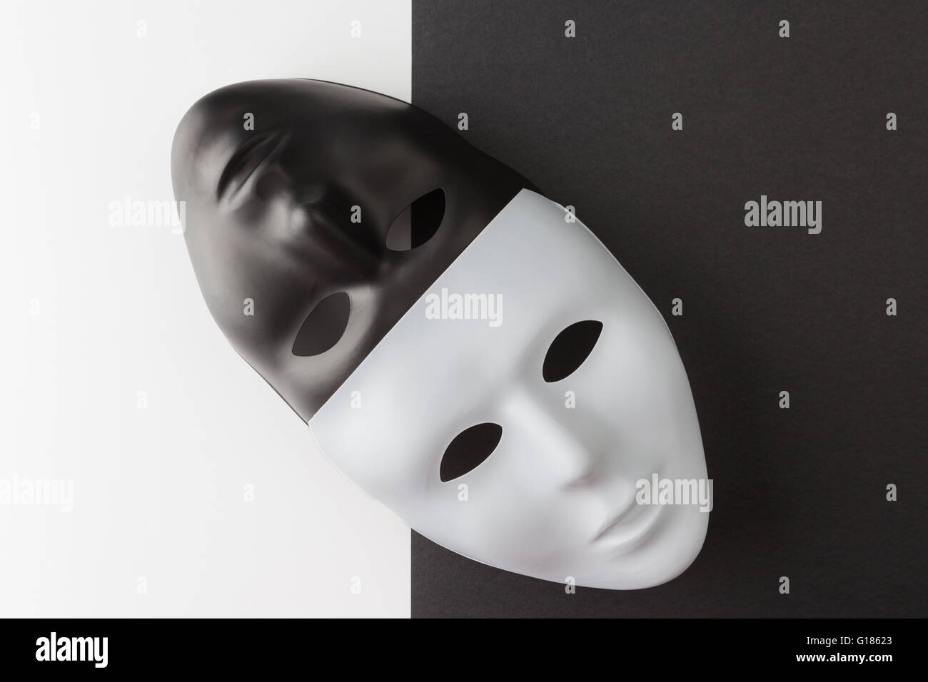 Las máscaras en blanco y negro colocados diagonalmente sobre un fondo contrastante. Concepto de anonimato en la Web Foto de stock