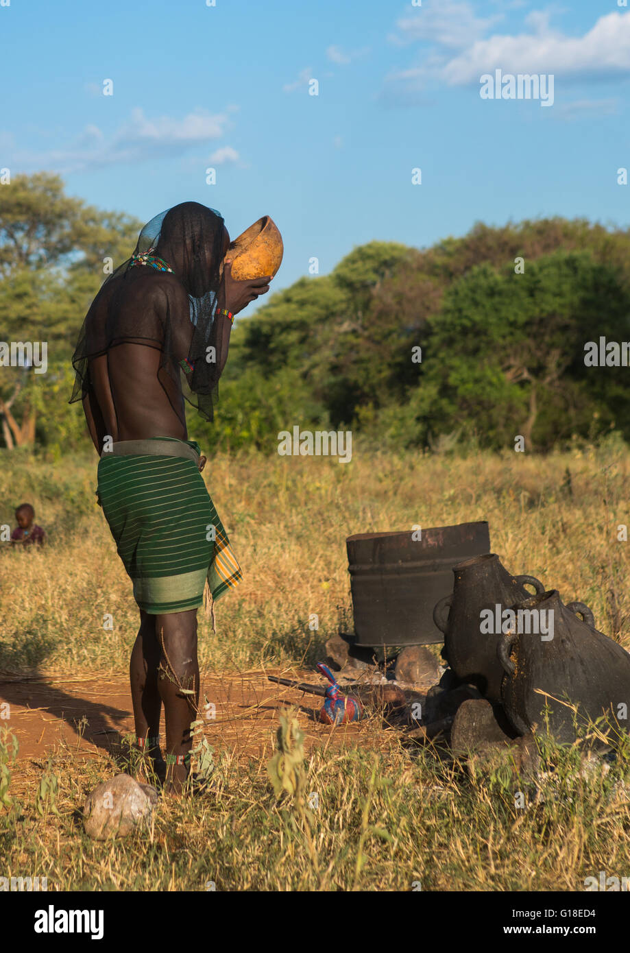 Hamer tribu azotador beber durante un toro saltando ceremonia, omo valley, Turmi, Etiopía Foto de stock