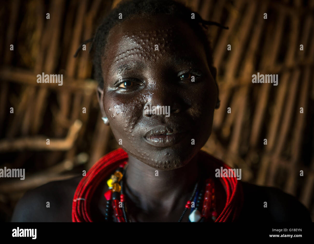 Etnia Toposa tribu mujer con escarificado cara roja y collares, omo valley, Kangate, Etiopía Foto de stock
