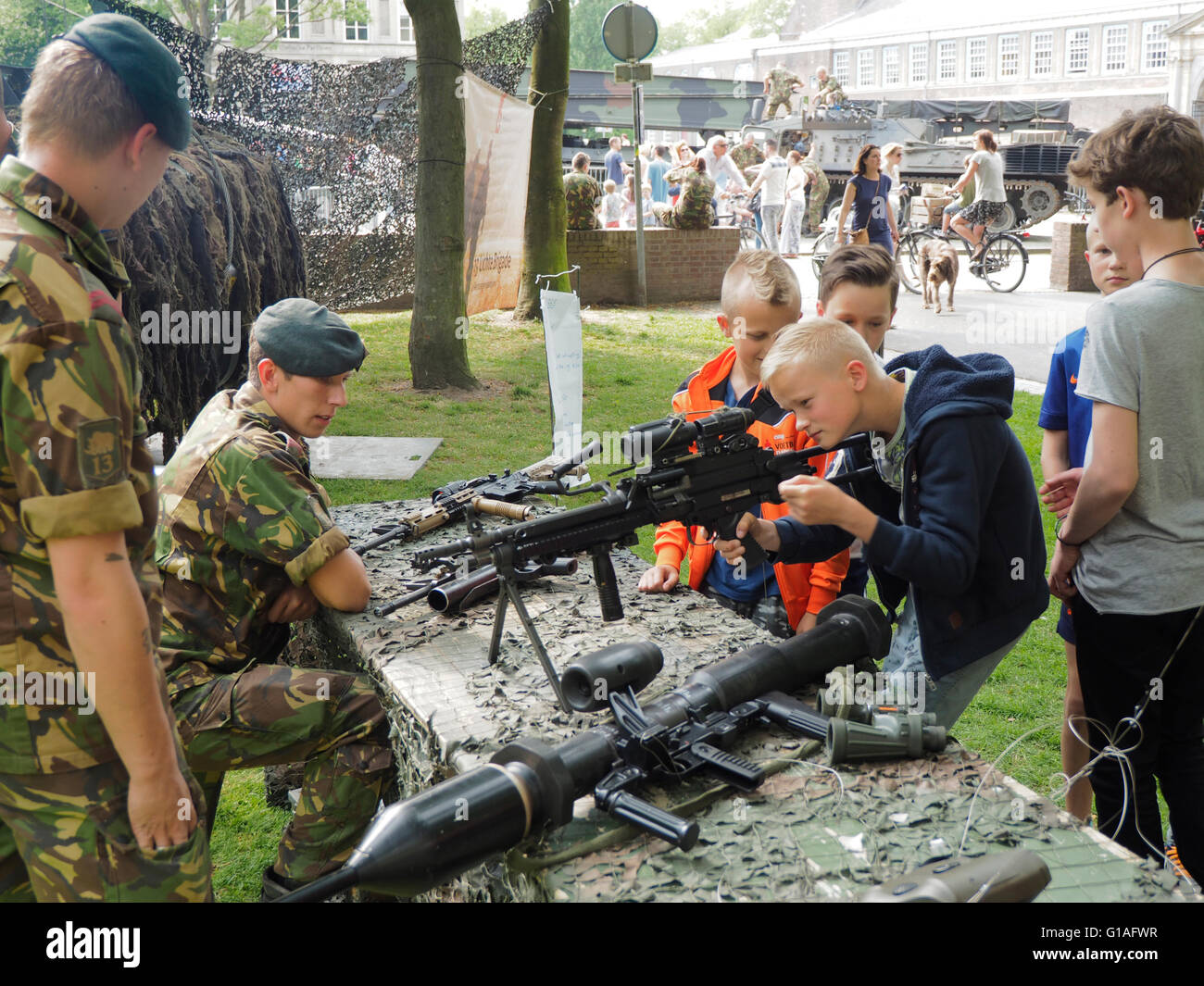Soldado del ejército holandés que muestran diversas armas y armamento a los niños en el parque Valkenberg, Breda, Holanda. Foto de stock