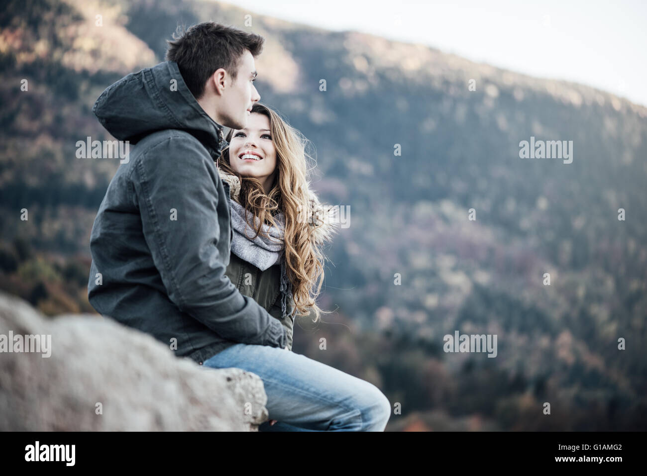 Romántica pareja joven dating en invierno están sentados juntos, ella está en busca de su novio Foto de stock