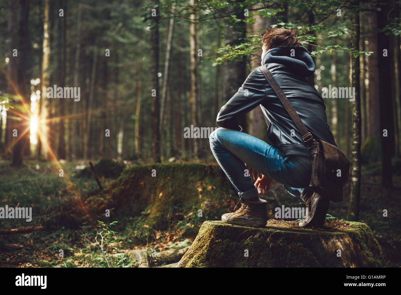 Joven apuesto hombre de explorar el bosque y mirar a su alrededor, la naturaleza y el concepto de la libertad Foto de stock