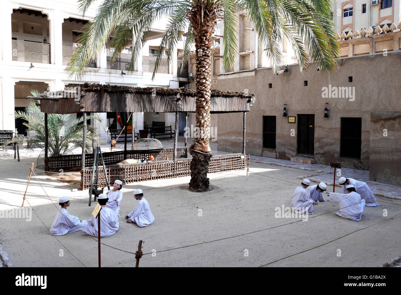 Patio de la casa del patrimonio, con vestidos tradicionalmente muchachos jugando, Deira, Dubai, Emiratos Árabes Unidos. Foto de stock