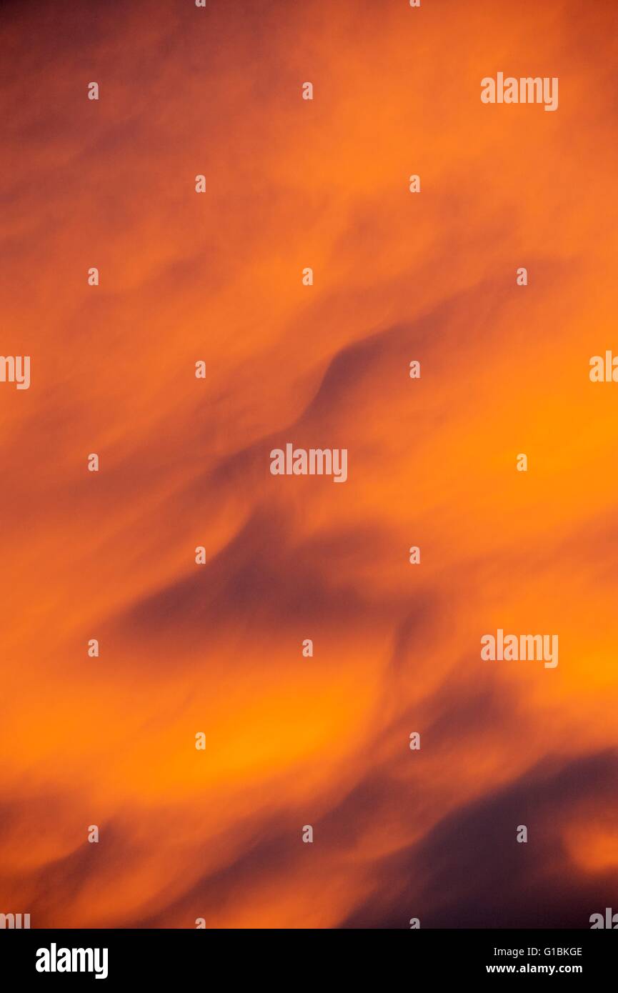 Cerca de las nubes del amanecer naranja en otoño, Wales, REINO UNIDO Foto de stock