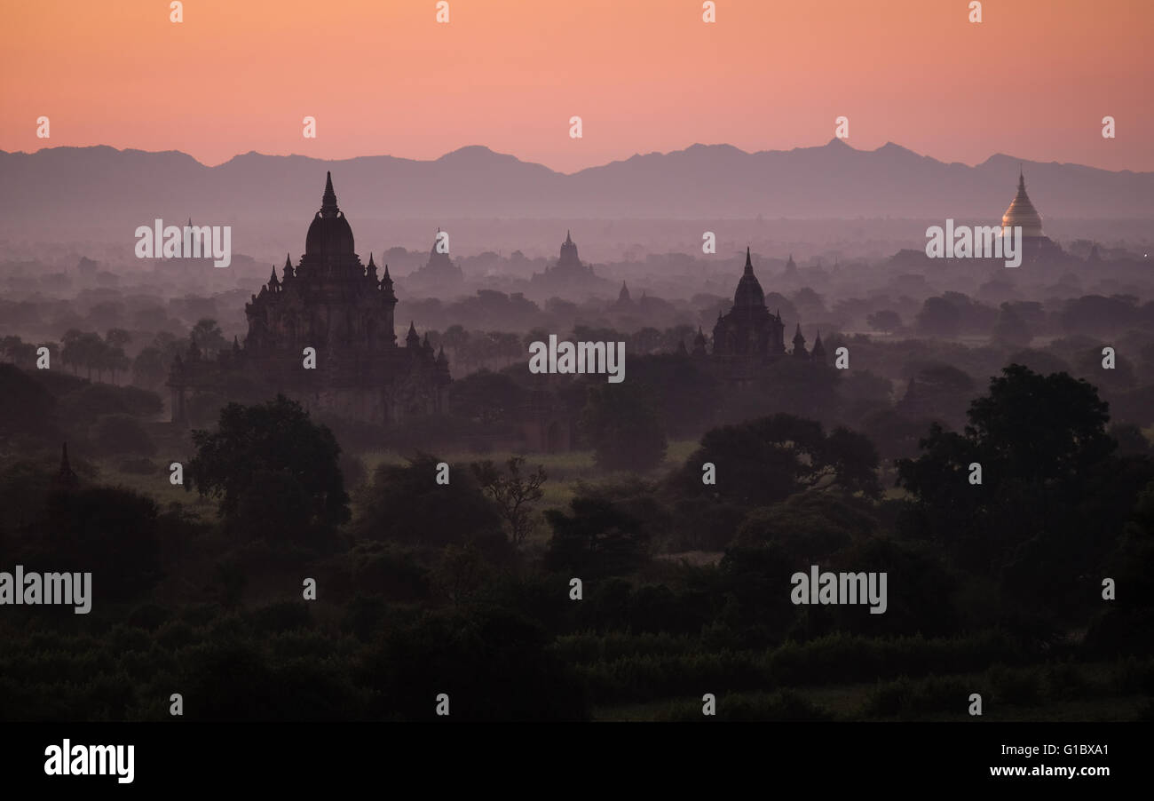 Amanecer sobre los antiguos templos de Bagan esparcidos por el brumoso paisaje Foto de stock