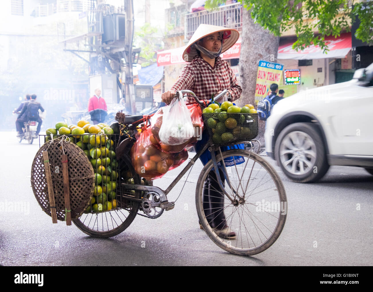 Un vendedor ambulante vendiendo naranjas en el barrio antiguo de Hanoi, Vietnam Foto de stock