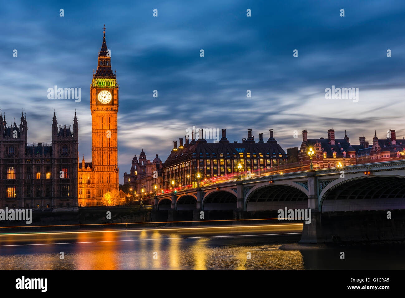 La larga exposición al anochecer de autobuses en Westminster Bridge y botes en el río Támesis, Londres, Reino Unido. Foto de stock