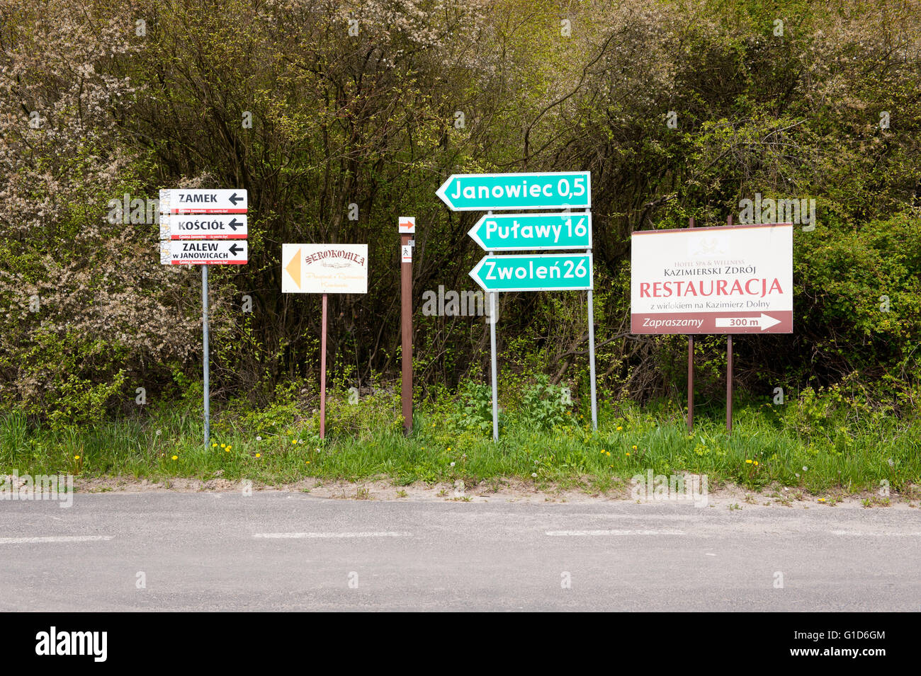 Lugares de interés supuesto letrero por la carretera rural, mostrando la información de direcciones a Janowiec, Pulawy y Zwolen sino también el castillo Foto de stock