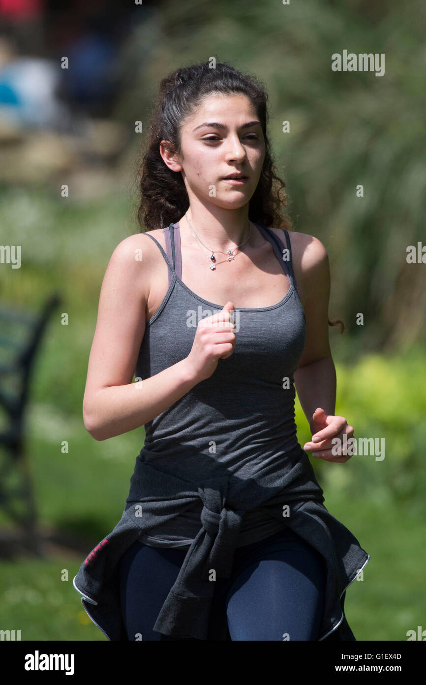 Una mujer mantiene en forma haciendo ejercicio corriendo haciendo footing en un parque. Foto de stock