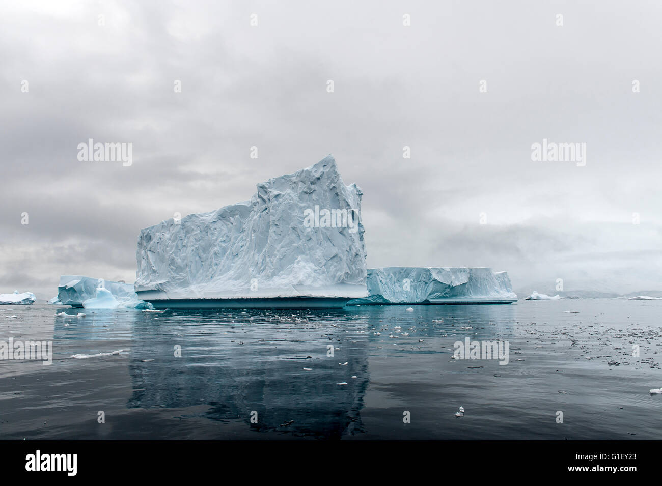 Azul hielo flotante, reflexión y moody sky Cierva Cove Península Antártica La Antártida Foto de stock
