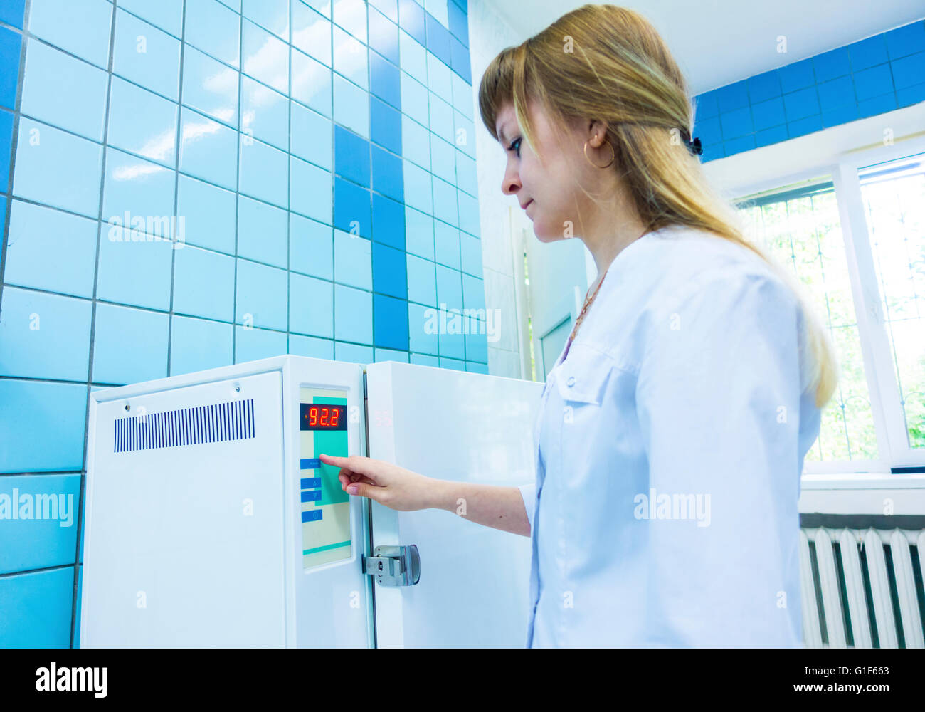 Modelo liberado. Trabajador farmacéutica esterilización de funcionamiento de la máquina. Foto de stock