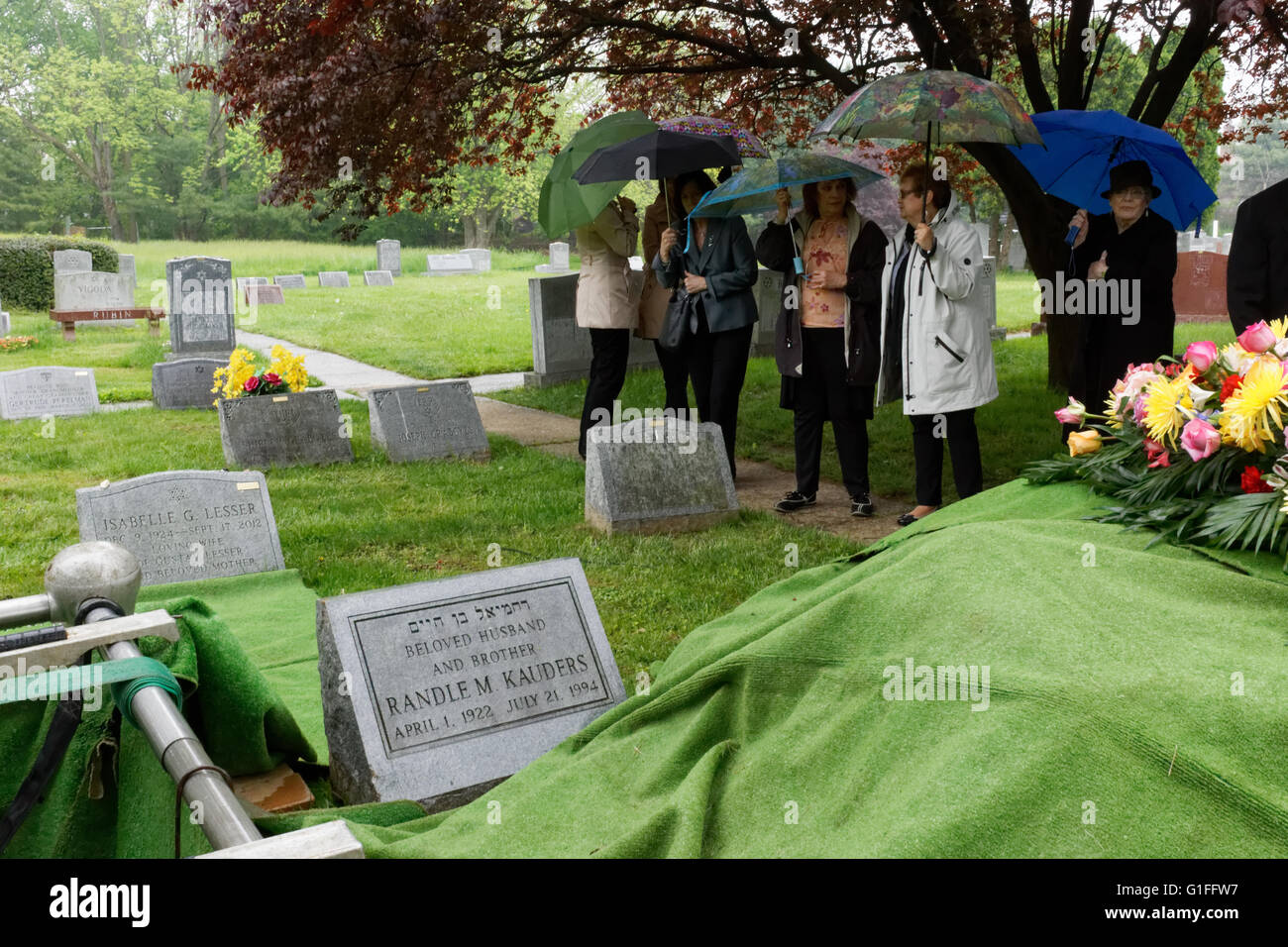Los dolientes parado en la lluvia esperando el comienzo de un entierro en el cementerio de Har Jehuda en Upper Darby, Pennsylvania. Foto de stock