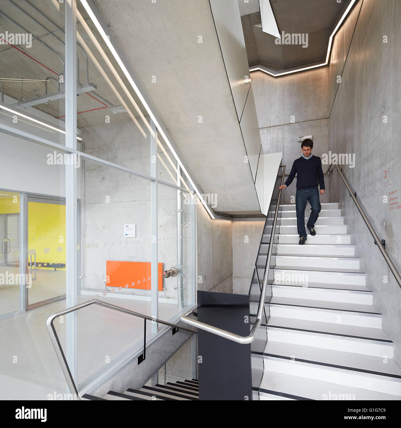 Escalera con figura descendente. El grafeno Institute de la Universidad de Manchester, Manchester, Reino Unido. Arquitecto: Jestico + Whiles, 2015. Foto de stock