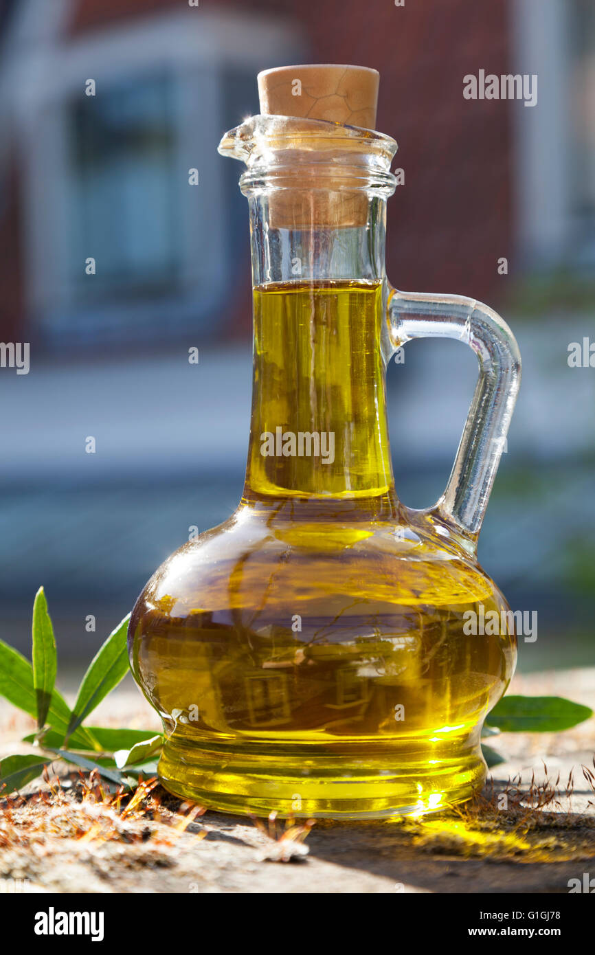 Botella de aceite de oliva en el exterior en el sol Foto de stock