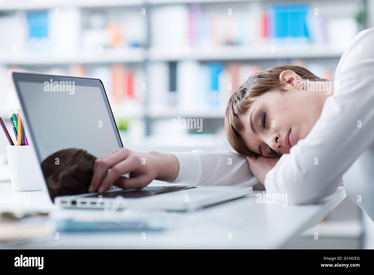 Cansado empresaria durmiendo en su escritorio y apoyándose en su brazo Foto de stock
