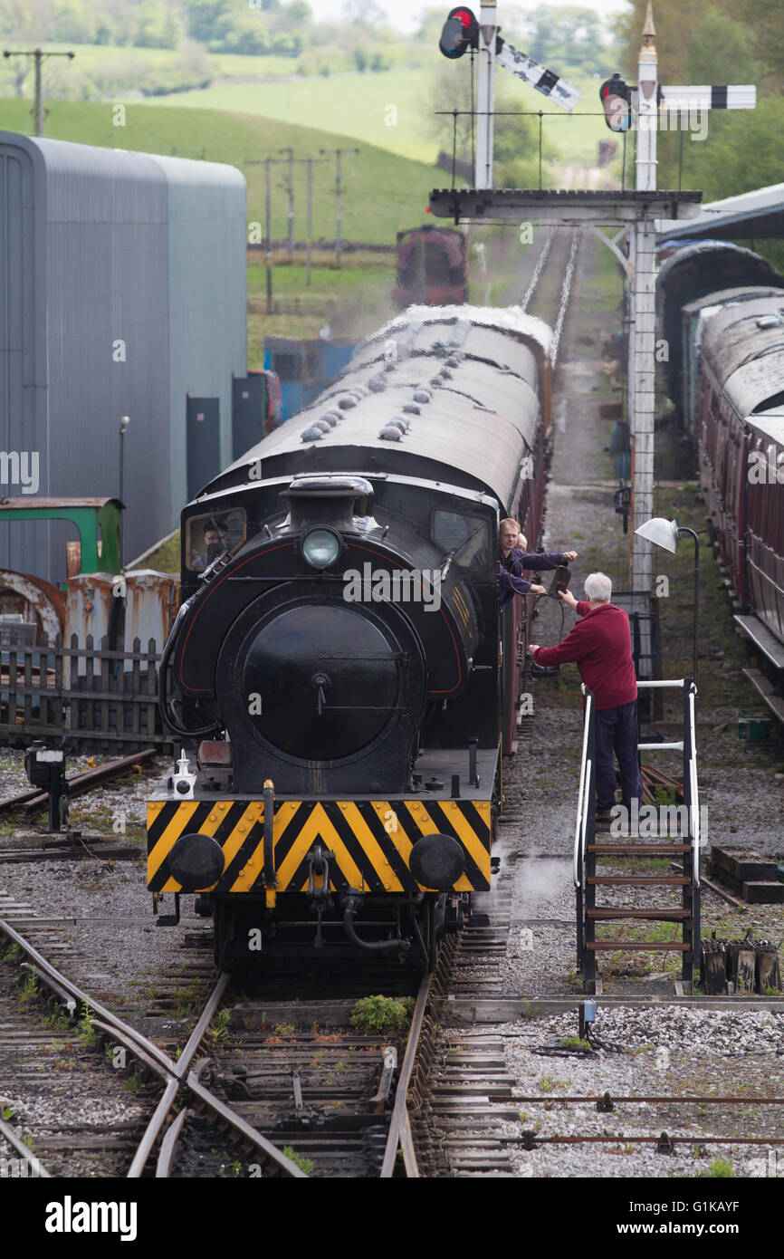 El signalman conductor de tren de vapor y el intercambio de una sola línea y Embsay tokens en el Bolton Abbey Railway cerca de Skipton Foto de stock