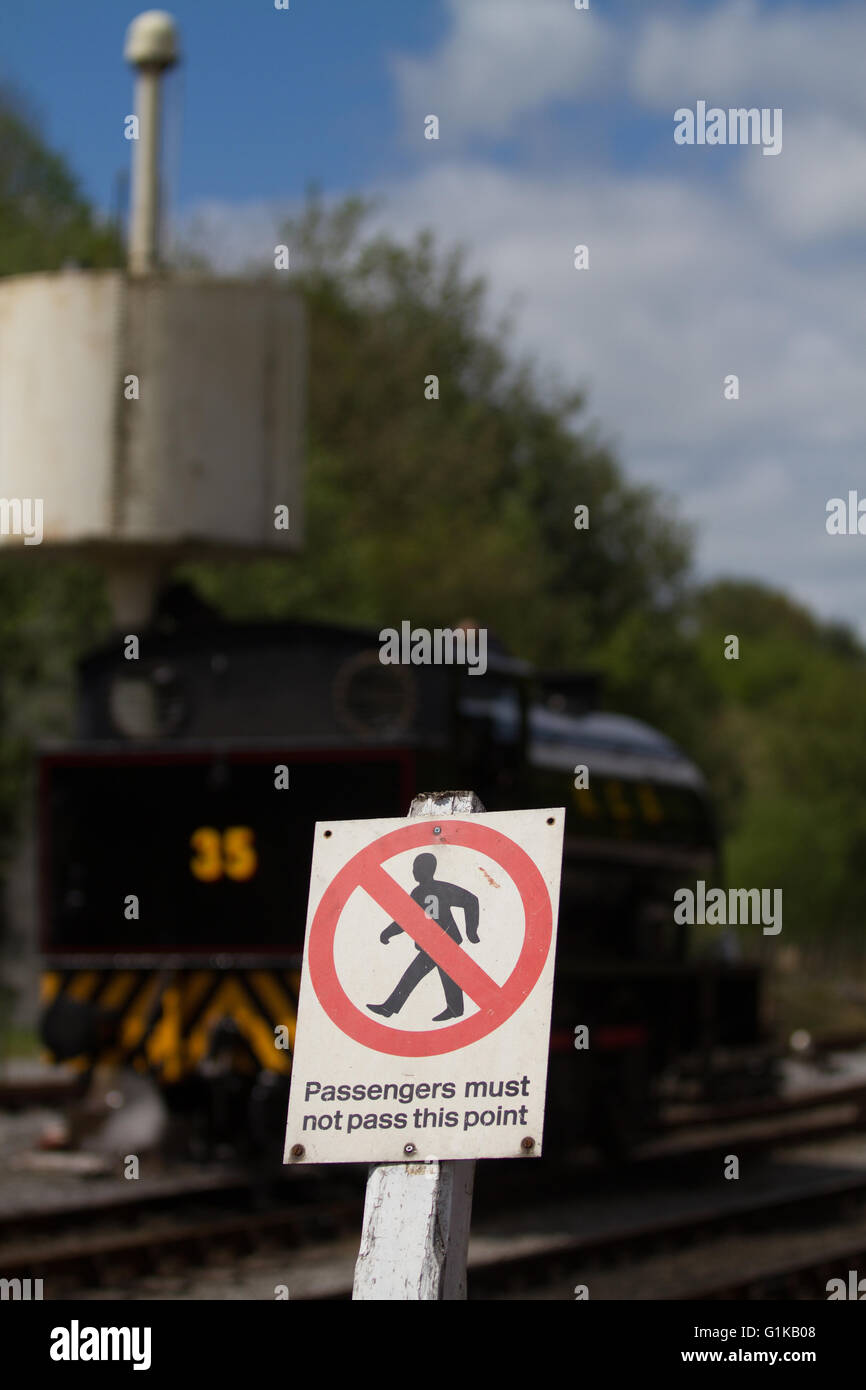 Locomotora de vapor está detrás de un aviso indicando la prohibición contra la prevaricación de ferrocarril en Bolton Abbey. Foto de stock