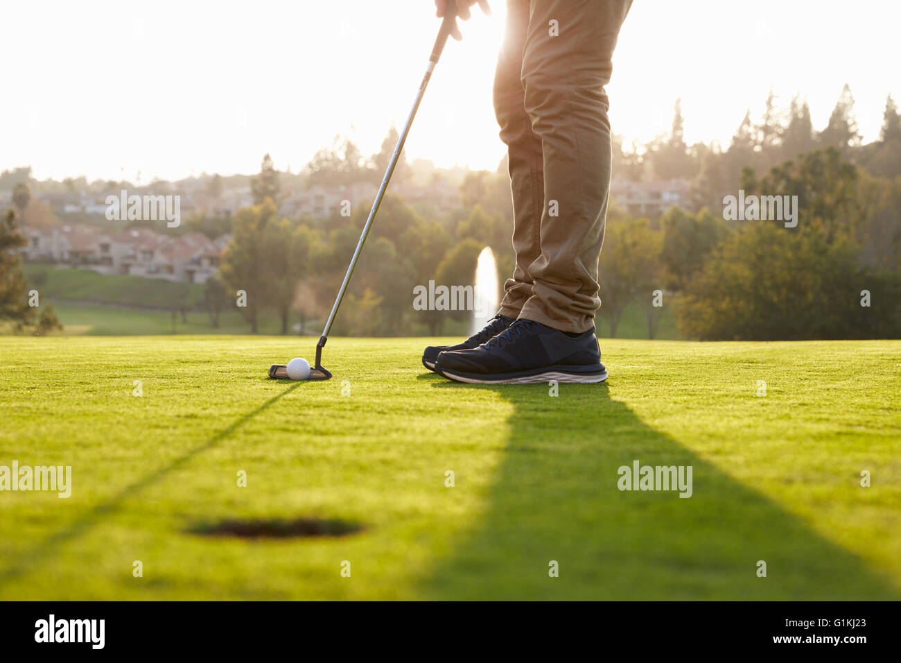 Cerca de golfista masculino Alineando Putt en verde Foto de stock