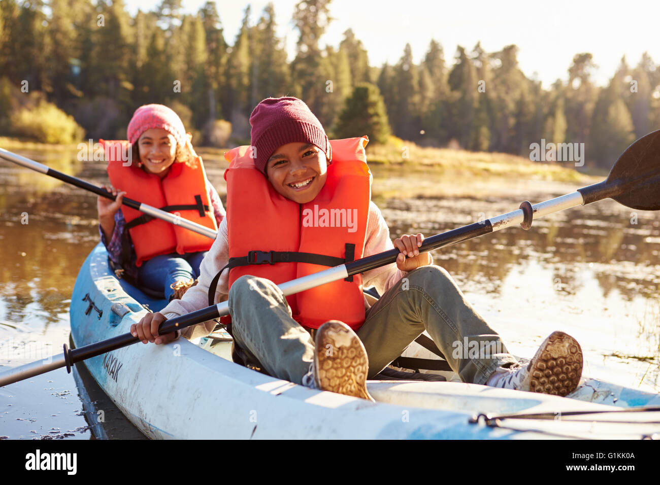 Dos niños Remo Kayak en el lago Foto de stock