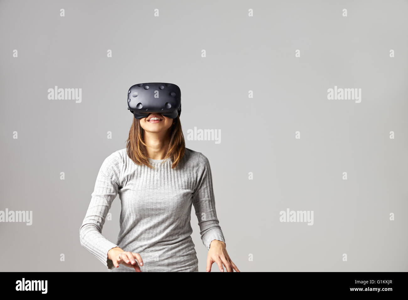 Hombre sentado en el sofá en casa vistiendo casco de realidad virtual Foto de stock