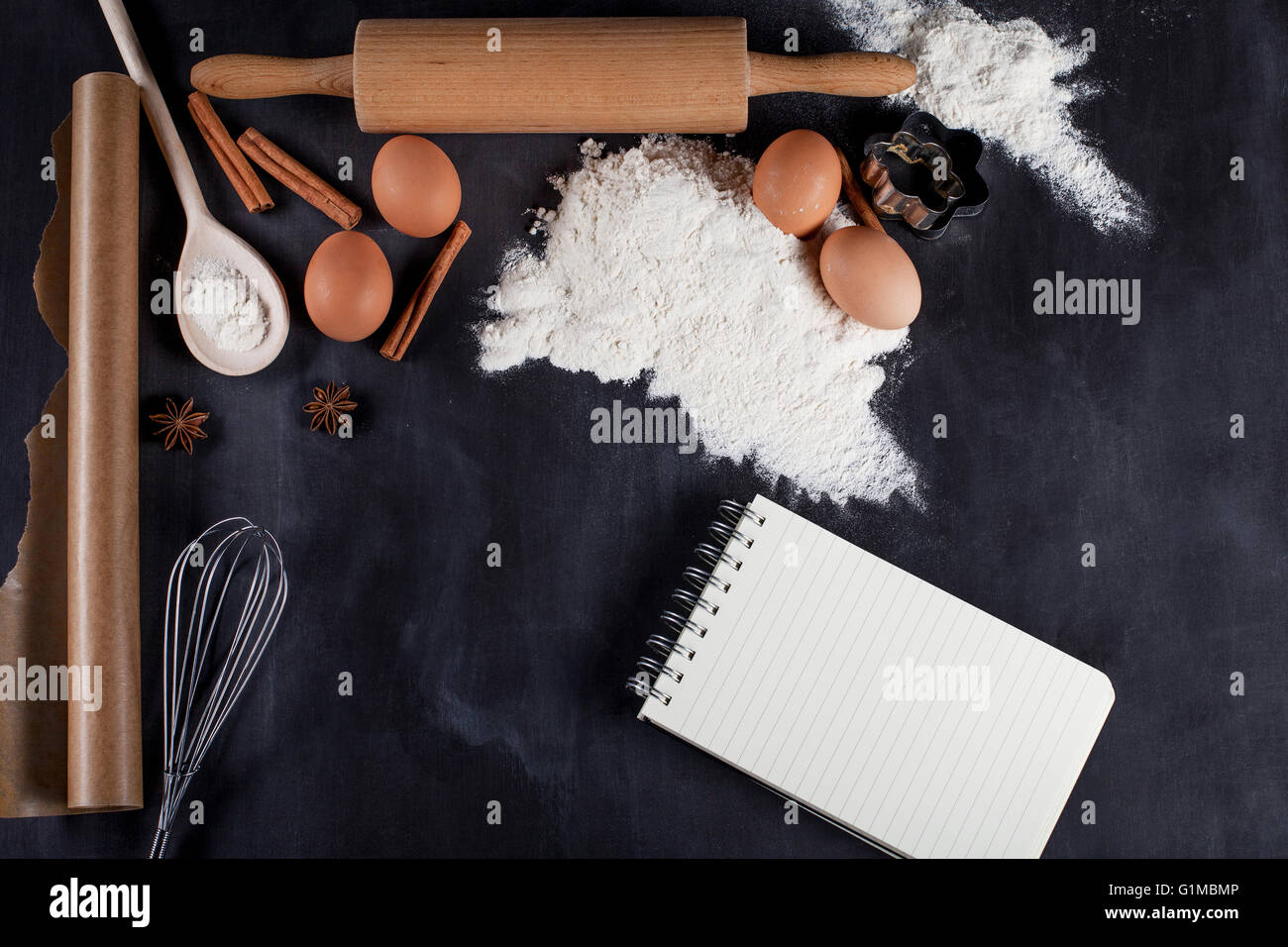 Ingredientes como los huevos, la harina, la canela, el anís, rodillo, papel encerado Foto de stock