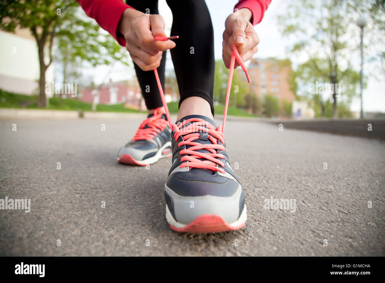Mujer deportiva shoelace atado en zapatillas antes de la práctica. La  preparación de la atleta femenina para correr al aire libre Fotografía de  stock - Alamy
